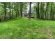 A sprawling backyard lawn features mature trees and a view of the home's deck at 4806 Deer Chase, Powder Springs, GA 30127