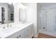 Bright bathroom featuring a double vanity with white countertops, brushed gold hardware, and a glass-enclosed shower at 4806 Deer Chase, Powder Springs, GA 30127