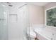 Bathroom with walk-in shower, toilet, tub, and a window with natural light at 4806 Deer Chase, Powder Springs, GA 30127