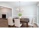 Elegant dining room features modern chandelier, table, seating, and an adjoining fireplace at 4806 Deer Chase, Powder Springs, GA 30127
