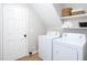 Bright laundry room featuring a washer, dryer, and shelving for convenient storage solutions at 4806 Deer Chase, Powder Springs, GA 30127