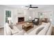 Bright living room featuring a cozy fireplace, neutral furniture, and an adjoining dining area at 4806 Deer Chase, Powder Springs, GA 30127
