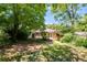 Landscaped backyard featuring a well-maintained lawn, mature trees, and a charming deck with French doors at 1405 May Se Ave, Atlanta, GA 30316
