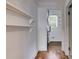 Hallway with hardwood floors, shelves, and access to a room containing the water heater at 1405 May Se Ave, Atlanta, GA 30316