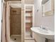 Modest bathroom featuring a tiled shower with curtain and pedestal sink at 265 Tamea Trl, Covington, GA 30014