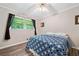 Cozy bedroom with a bed dressed with a blue quilt, hardwood floors, and bright window at 265 Tamea Trl, Covington, GA 30014