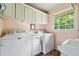 Bright laundry room features Maytag washer and dryer, storage cabinets, and window at 265 Tamea Trl, Covington, GA 30014