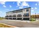 Modern townhome row featuring brick facade, private balconies, and individual one car garages on a sunny day at 445 Breccia Run, Mcdonough, GA 30253