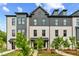 Beautiful view of a new construction white brick townhome with professional landscaping at 445 Breccia Run, Mcdonough, GA 30253