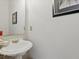 Bathroom featuring a pedestal sink with gold fixtures and a neutral color palette at 6772 Blantyre Boulevard Blvd, Stone Mountain, GA 30087