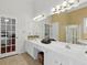 Bathroom featuring dual vanities, large mirror, tan tile floors, and a shower and bathtub combo at 6772 Blantyre Boulevard Blvd, Stone Mountain, GA 30087