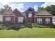 Charming two-story brick home featuring a manicured lawn and mature landscaping at 6772 Blantyre Boulevard Blvd, Stone Mountain, GA 30087