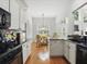Bright kitchen with white cabinets and hardwood floors, open to the dining and living areas at 6772 Blantyre Boulevard Blvd, Stone Mountain, GA 30087