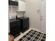 Modern laundry room featuring dark washer, dryer, overhead storage, and stylish black and white rug at 6772 Blantyre Boulevard Blvd, Stone Mountain, GA 30087