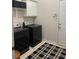 Well-lit laundry area with white cabinets, black washer/dryer, and a black and white rug at 6772 Blantyre Boulevard Blvd, Stone Mountain, GA 30087