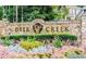 Stone sign with gold lettering and landscaped garden, displaying the Deer Creek community name at 6772 Blantyre Boulevard Blvd, Stone Mountain, GA 30087