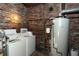 Basement features a water heater and washer with exposed brick and utility connections at 819 Durant Ne # 819-6, Atlanta, GA 30308