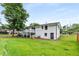 Large backyard featuring well-maintained lawn, mature trees, and a white painted brick home at 1055 Delmont Ter, Roswell, GA 30075