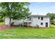 View of backyard with a white painted brick home, a deck, and ample lawn space at 1055 Delmont Ter, Roswell, GA 30075