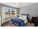 Bedroom boasts a large window with natural light, hardwood floors, and a comfortable bed at 1055 Delmont Ter, Roswell, GA 30075