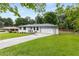 Charming white brick ranch home with a long driveway and a well-manicured lawn at 1055 Delmont Ter, Roswell, GA 30075