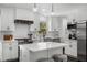 Modern kitchen with white cabinets, stainless steel appliances, a center island, and a stylish backsplash at 1055 Delmont Ter, Roswell, GA 30075