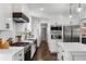 Bright kitchen boasts white cabinetry, stainless steel appliances, and a center island with pendant lighting at 1055 Delmont Ter, Roswell, GA 30075