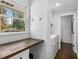 Well-lit laundry room featuring built-in desk, shiplap walls, and modern washer and dryer at 1055 Delmont Ter, Roswell, GA 30075