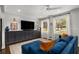 Bright living room with a large sofa, sleek entertainment center, and ample natural light from the windows at 1055 Delmont Ter, Roswell, GA 30075