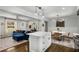 A modern living room boasts a blue sofa, neutral walls, and an open layout adjoining the kitchen and breakfast nook at 1055 Delmont Ter, Roswell, GA 30075