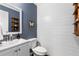 Stylish powder room features shiplap walls, modern sink, and decorative shelving at 1055 Delmont Ter, Roswell, GA 30075