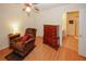 Comfortable bedroom with wood floors, ceiling fan, chair, dresser, and access to an attached bathroom at 2191 Rockbridge Rd # 103, Stone Mountain, GA 30087