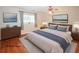 This virtually staged bedroom features a cozy king bed, wood flooring, and plenty of natural light from the window at 2191 Rockbridge Rd # 103, Stone Mountain, GA 30087