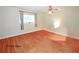 This bedroom is virtually staged with wood flooring, window, and a ceiling fan at 2191 Rockbridge Rd # 103, Stone Mountain, GA 30087