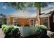 Brick home featuring a chimney, manicured landscaping, and a white picket fence at 2191 Rockbridge Rd # 103, Stone Mountain, GA 30087