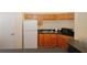 Well-lit kitchenette featuring wooden cabinets, a refrigerator, a microwave, and a double sink at 2191 Rockbridge Rd # 103, Stone Mountain, GA 30087