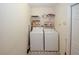 Functional laundry area with washer, dryer, and overhead storage shelves at 2191 Rockbridge Rd # 103, Stone Mountain, GA 30087