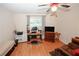 Bright room set up as an office with a ceiling fan and warm wood floors at 2191 Rockbridge Rd # 103, Stone Mountain, GA 30087
