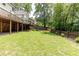Large backyard features a well-maintained lawn, a privacy fence, mature trees, and access to a wooden deck at 3707 Dunwoody Club Dr, Atlanta, GA 30350
