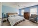 Well-lit blue bedroom with a decorative bed and patterned armchair at 3707 Dunwoody Club Dr, Atlanta, GA 30350