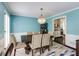 Bright dining room with wood floors, light blue walls, white trim and a modern light fixture at 3707 Dunwoody Club Dr, Atlanta, GA 30350