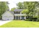 Charming two-story home featuring a well-manicured lawn, blue door, and a two-car garage at 3707 Dunwoody Club Dr, Atlanta, GA 30350