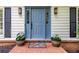 Close-up of a charming blue front door with sidelights, potted plants, and a colorful welcome mat at 3707 Dunwoody Club Dr, Atlanta, GA 30350