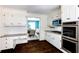 Kitchen with white cabinets, granite countertops, stainless steel appliances, desk and hardwood floors at 3707 Dunwoody Club Dr, Atlanta, GA 30350