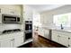 Bright kitchen with white cabinets, granite countertops, stainless steel appliances and hardwood floors at 3707 Dunwoody Club Dr, Atlanta, GA 30350