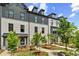 Charming townhome exterior with brick facade, black trim, landscaped yard, and inviting walkways under a partly cloudy sky at 441 Breccia Run, Mcdonough, GA 30253