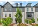 Charming townhome exterior with brick facade, black trim, landscaped yard, and inviting walkways under a partly cloudy sky at 441 Breccia Run, Mcdonough, GA 30253