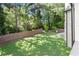 Spacious backyard features lush green grass, a charming fence line, and a view of mature trees at 5120 Falcon Chase Ln, Atlanta, GA 30342