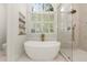 Bright bathroom featuring a soaking tub, glass shower, and large window at 5120 Falcon Chase Ln, Atlanta, GA 30342