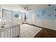 Charming Bedroom with a crib, soft blue walls, and whimsical airplane-themed decor at 5120 Falcon Chase Ln, Atlanta, GA 30342